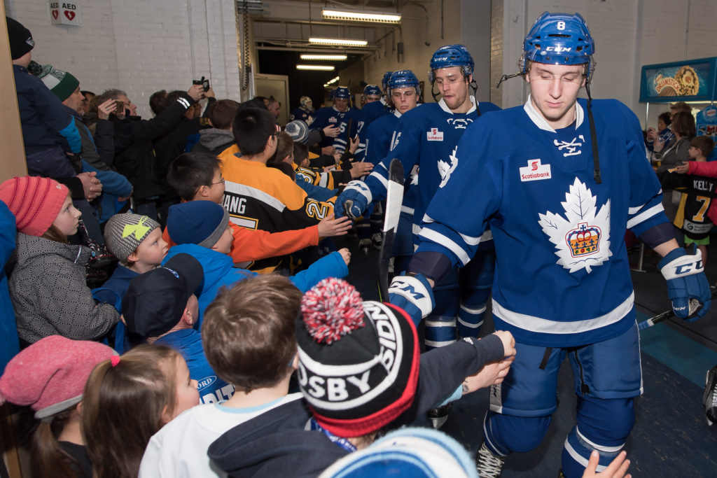 Minor hockey players give high-fives to the Marlies before a game.